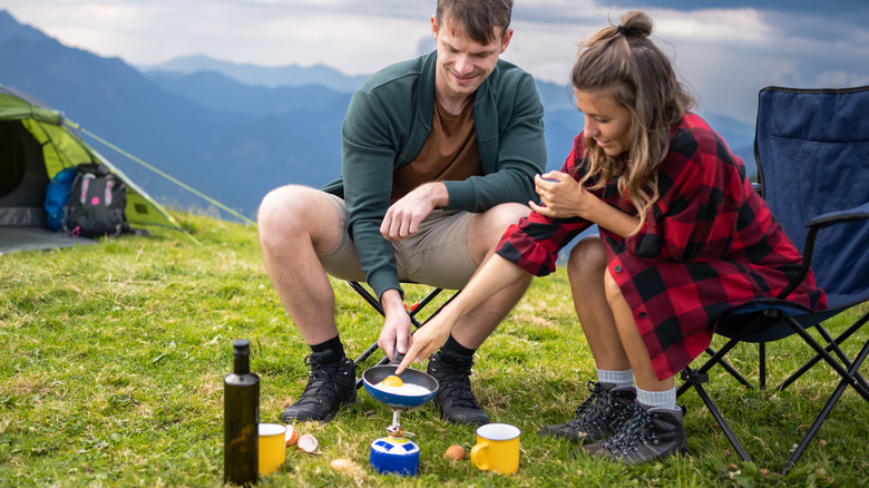 camping couple cooking meal