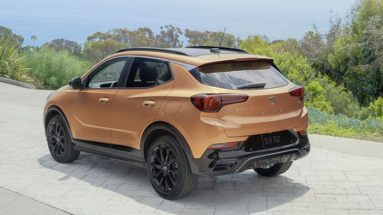 Orange Buick Encore GX modeled on pavement