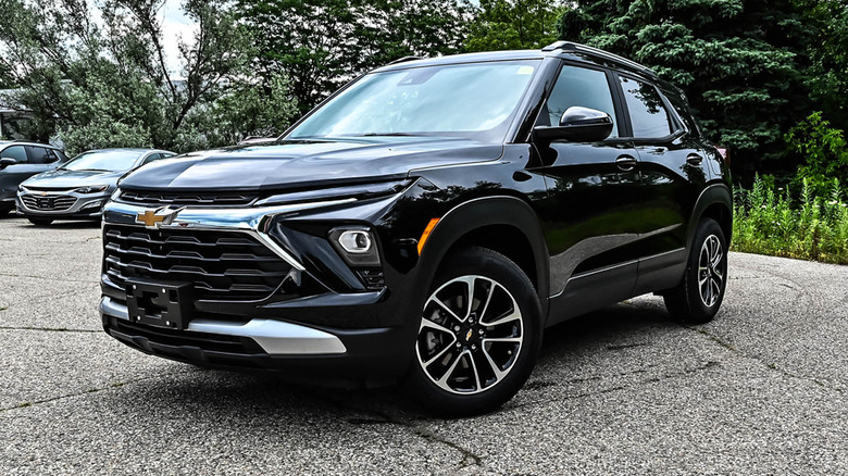Black Chevrolet TrailBlazer parked in front of a woody backdrop