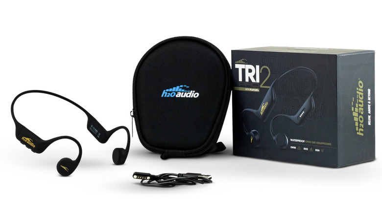 H2O waterproof bone conductor headphones next to carry case, cable and product box on a white background.