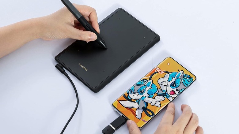 Huion H420X tablet connected to a smartphone.