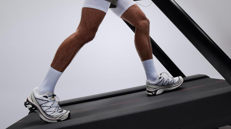 A person walking on a Peloton  Tread+ set on a steep incline.