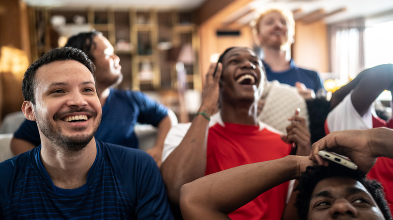 Sports fans watching a match at a house.