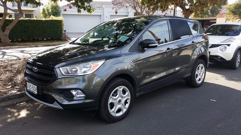 A 2017 Ford Escape parked by the sidewalk