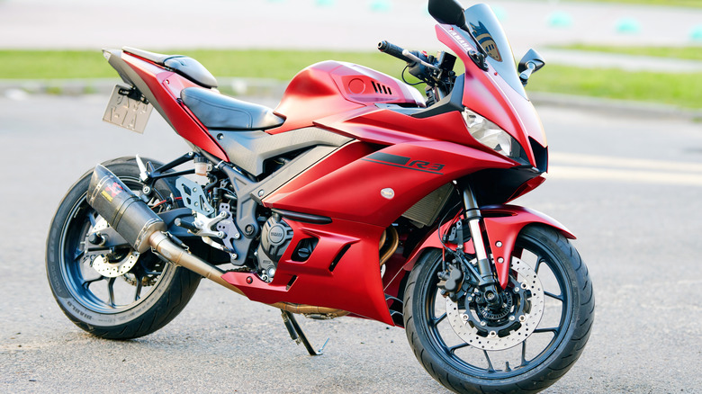 Bright red Yamaha R3 parked on road