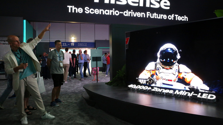 A person demonstrating a Hisense Mini LED television at a trade show