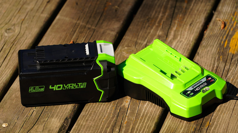 greenworks 40V lawn mower battery with its charging dock on the side