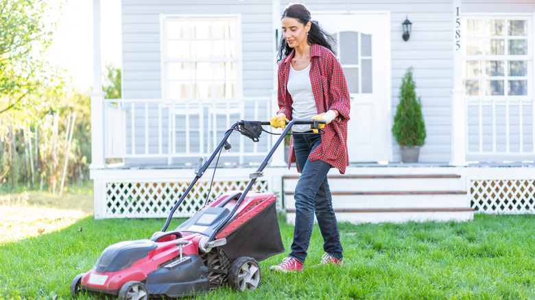 women operating a lawn mower in her backyard