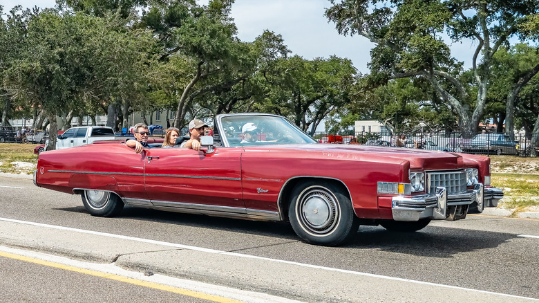 A right-front corner view of a red 1973 Cadillac Eldorado on a road