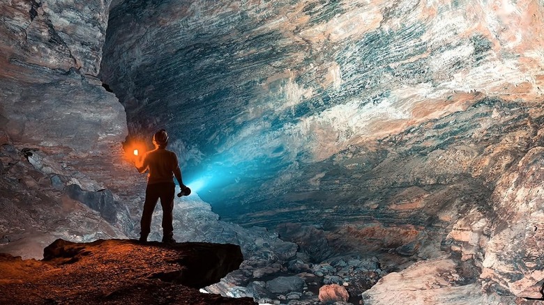 Person using a bright flashlight in a cave