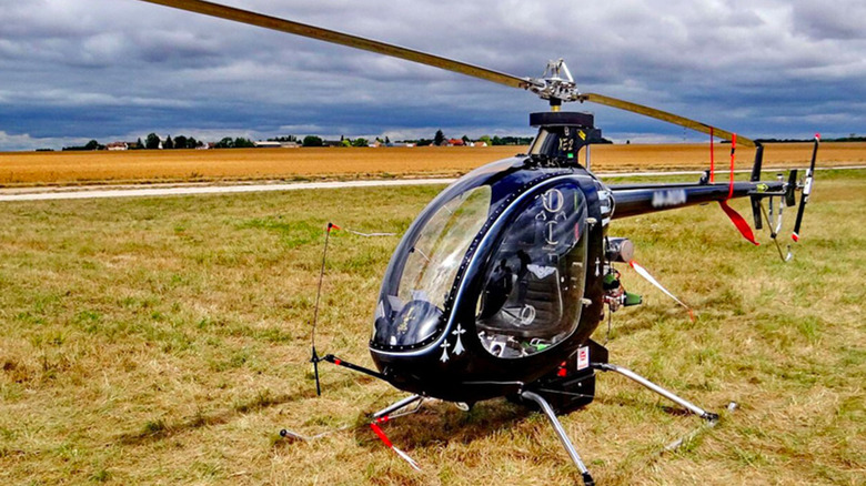 A Mosquito XE helicopter parked in a grassy field
