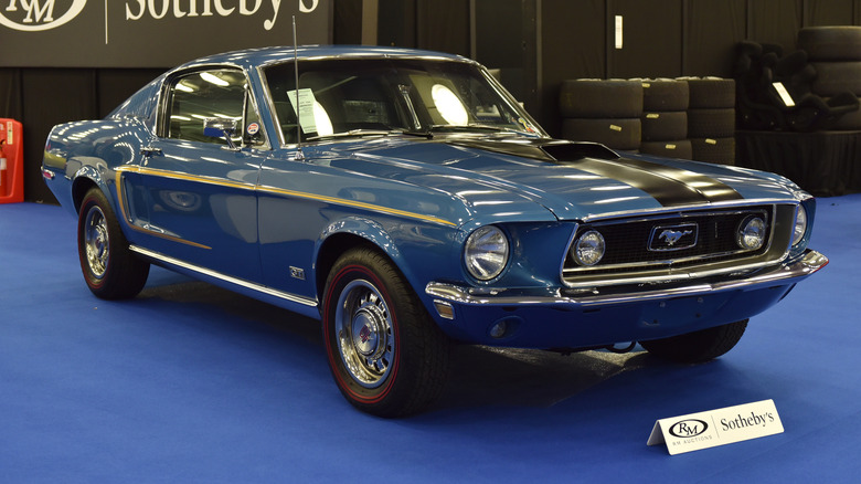 A 1968 Ford Mustang equipped with the Cobra Jet 428 engine on display at a Sotheby's auction podium.