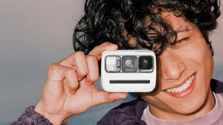 Person holding a Polaroid Go Instant Camera Generation 3 up to their right eye