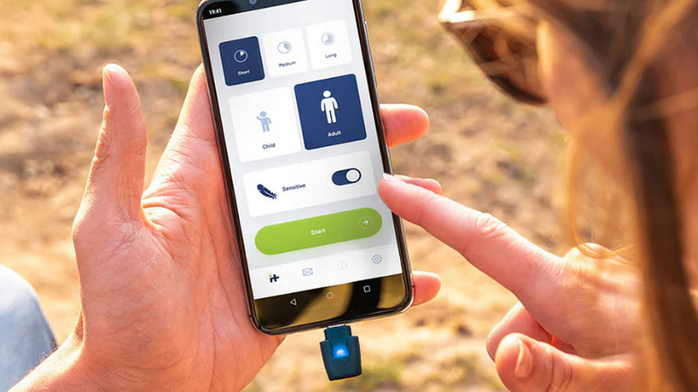 A Heat It Classic smartphone device plugged into a smartphone showing an app.