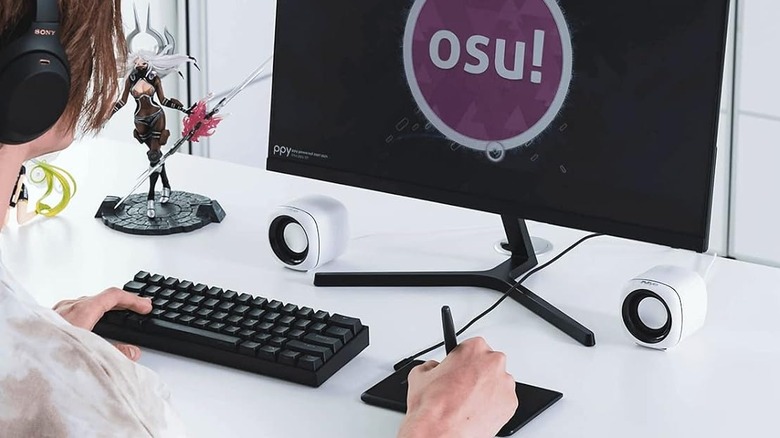 Someone using a Huion H420X drawing tablet to play Osu!