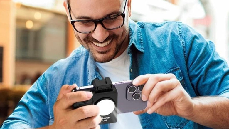 A man is using the Ulanzi Bluetooth Smartphone Cap Grip on his iphone to take photos