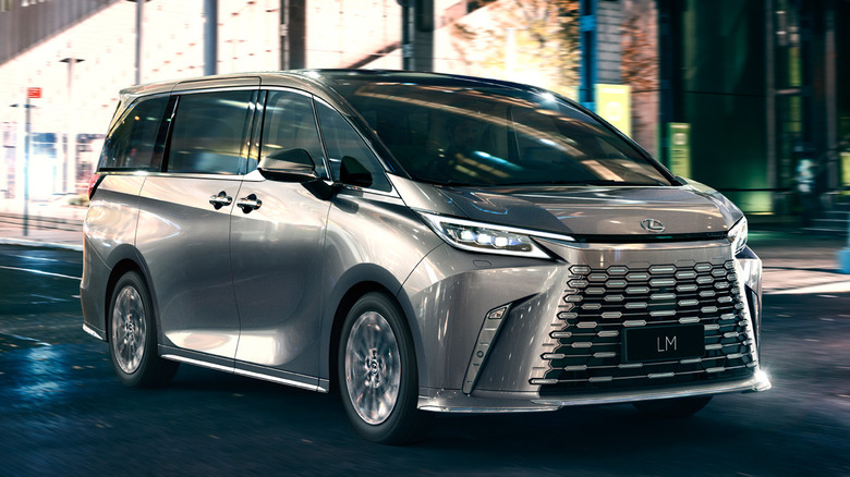 Silver Lexus LM on an urban road at night