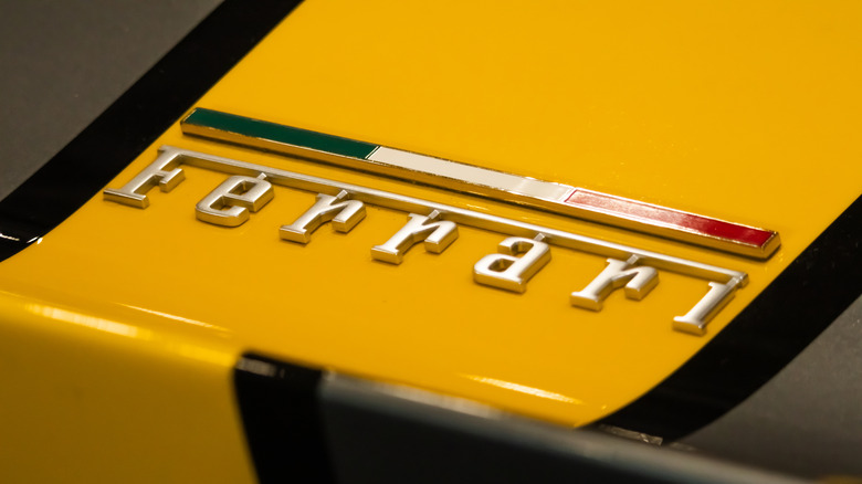 Close-up of a vintage Ferrari badge on a yellow vehicle
