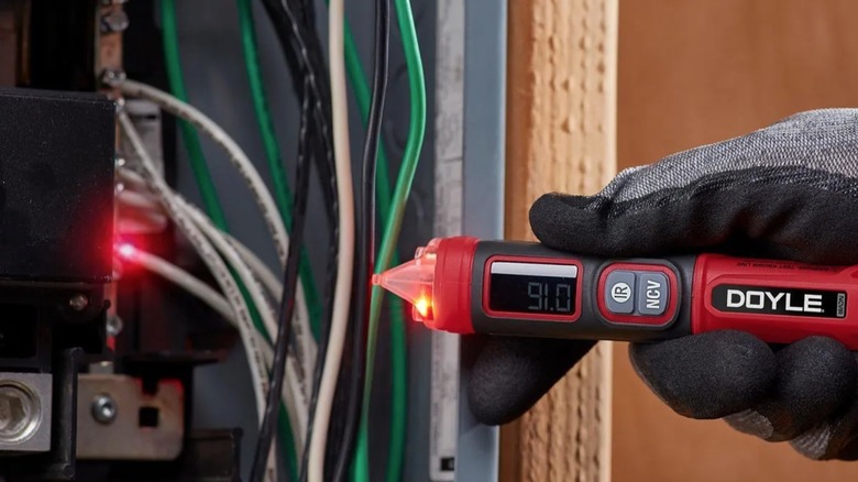 Perosn using Doyle voltage tester to test voltage