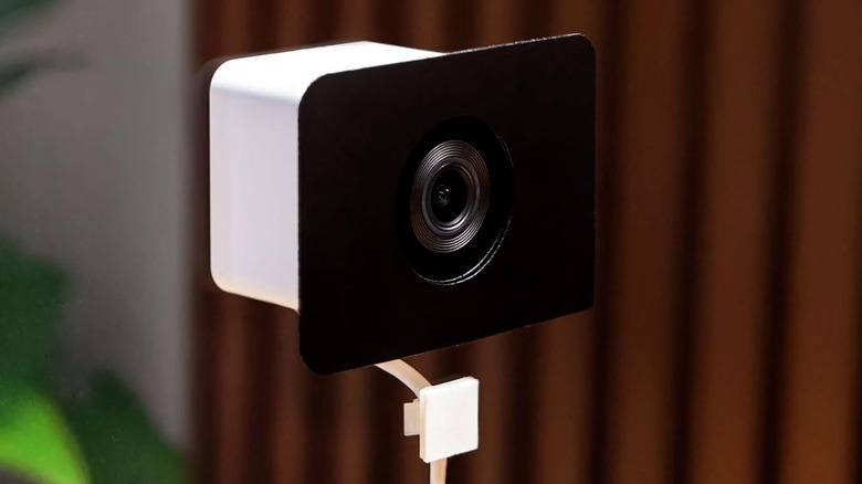 A Wyze Anti-Glare Indoor Window Security Camera attached to a window.