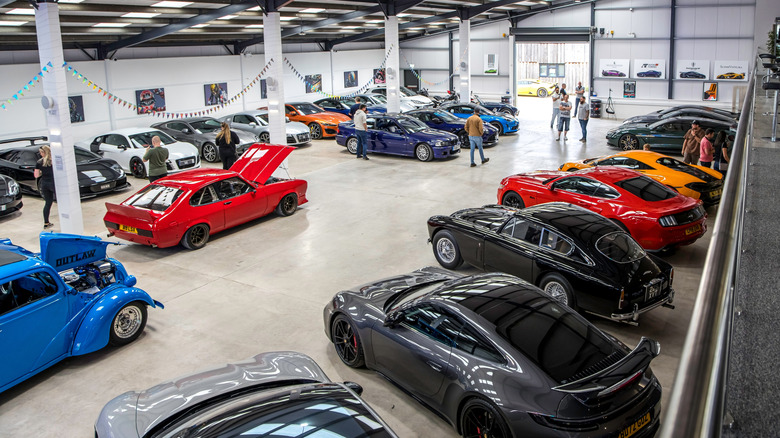 An automobile collection in a large hangar.