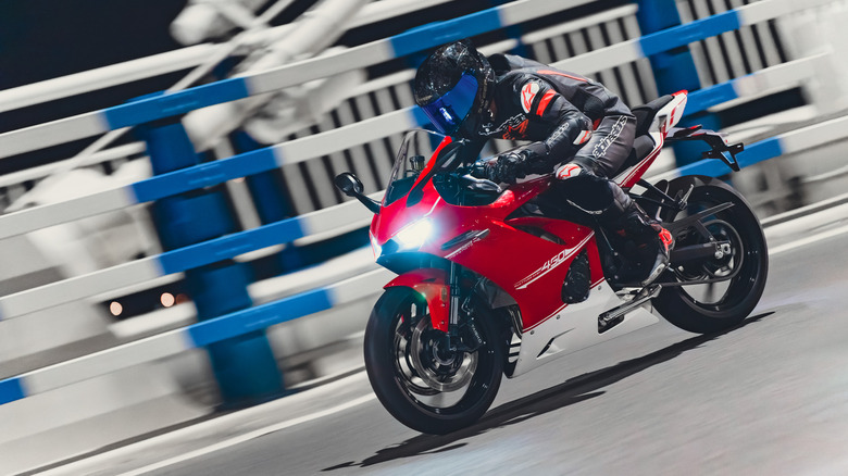 A man riding a Kove 450RR bike in red