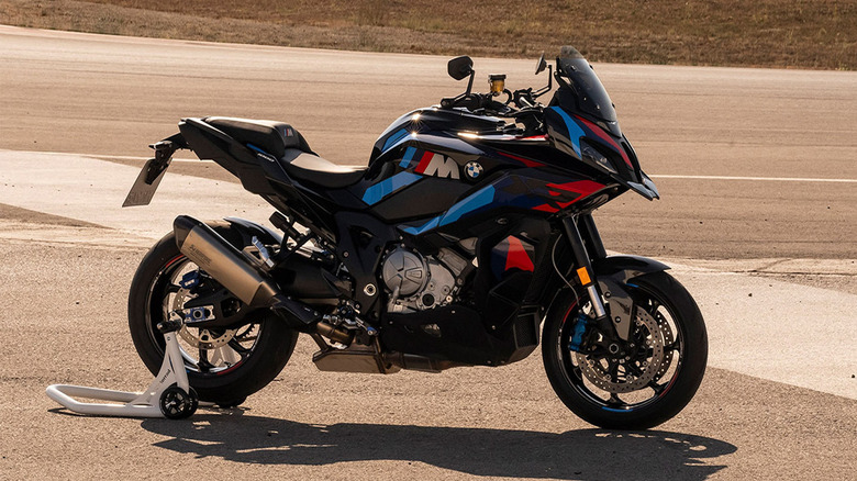 A black 2025 BMW M 1000 XR parked on a racetrack