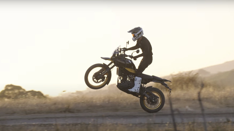 A shot of a man riding an adventure bike mid-jump