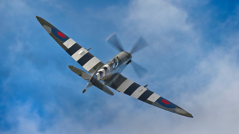 Supermarine Spitfire rear three quarter view flying away into a blue sky