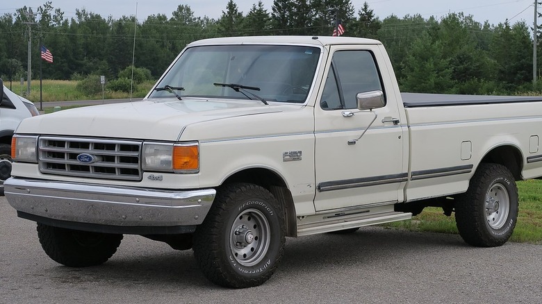 White Ford F-150 XLT Lariat parked on unpaved road.