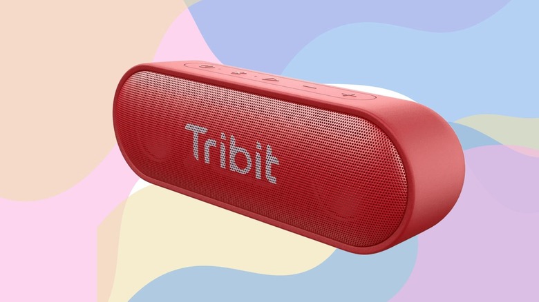 A Tribit XSound Go Bluetooth speaker against a pastel multicolor background
