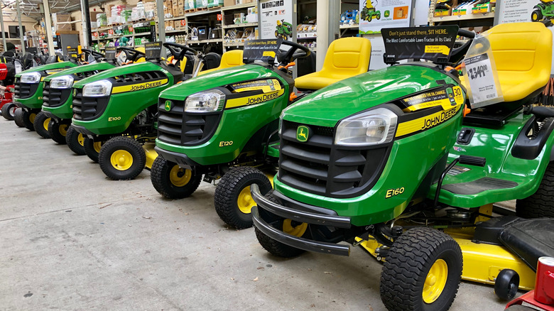 a line of John Deere riding lawn mowers for sale in a hardware store