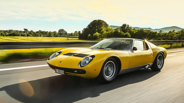 1971 Lamborghini Miura P400 SV driving along country road, front-left 3/4 view