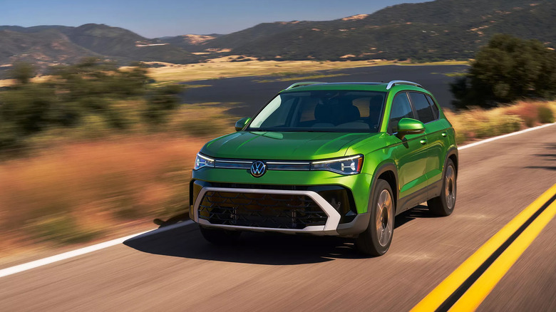 A green 2025 Volkswagen Taos driving