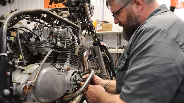 Mechanic fixing a broken down motorcycle in a workshop