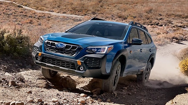 A blue 2025 Subaru Outback on a dirt road