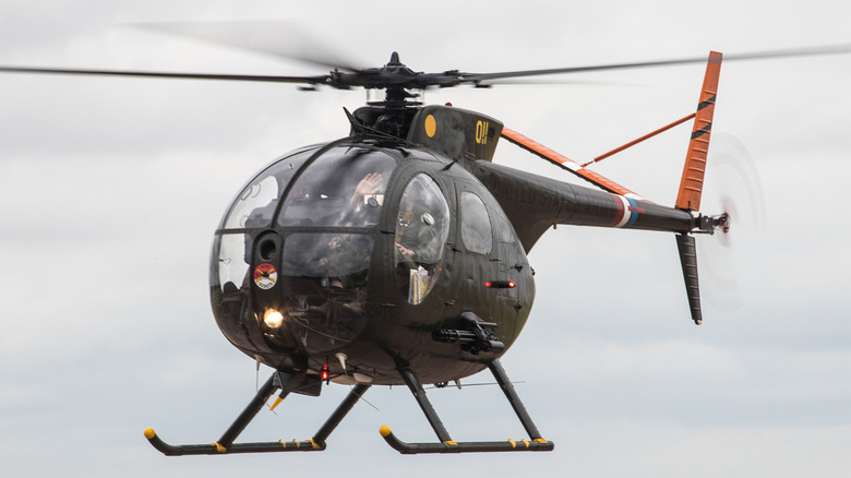 A Royal International Hughes OH-6A helicopter mid-flight