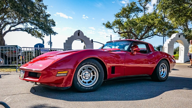 Red late model Chevrolet Corvette C3 at a car show, front 3/4 view