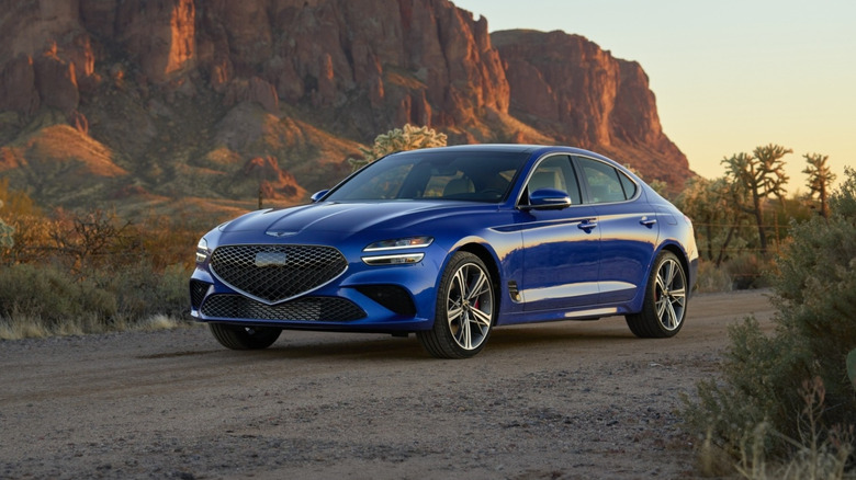 A blue 2026 Genesis G70 in the desert during dusk