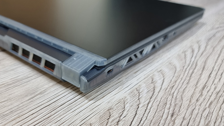 Closeup view of a laptop hinge as it rests on a table.