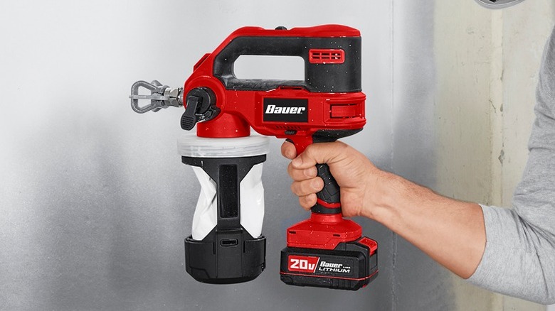 Person holding Bauer paint sprayer