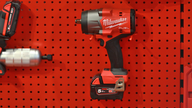 milwaukee drill with battery hanging on peg board