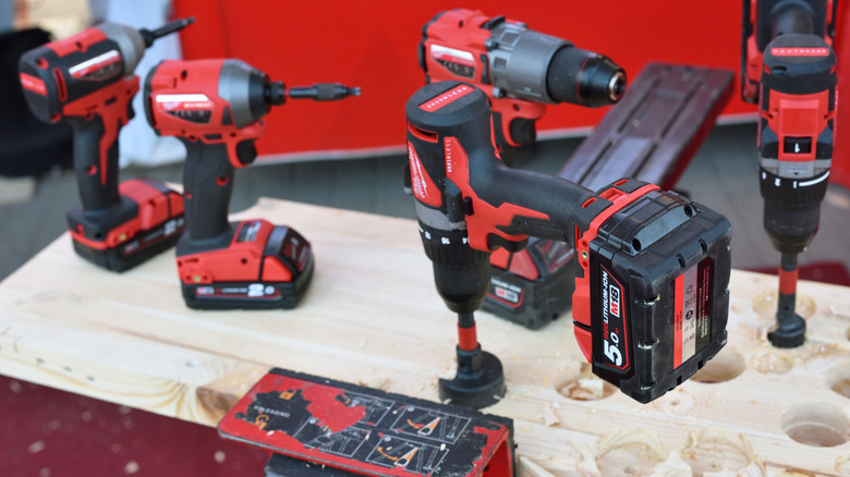 assortment of milwaukee power tools on wood