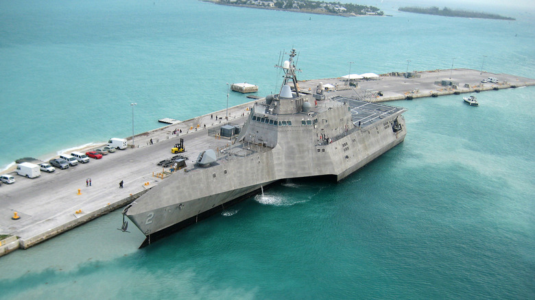 The USS Independence, a littoral combat ship anchored near a pier.