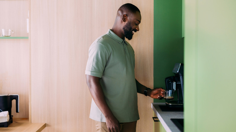 A person uses a coffee machine.
