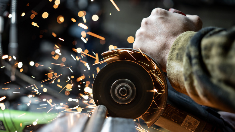 metal worker cutting metal using an angle grinder