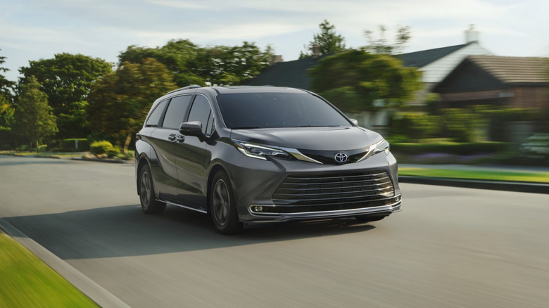 A gray 2026 Toyota Sienna on the move in a suburban area, front 3/4 view