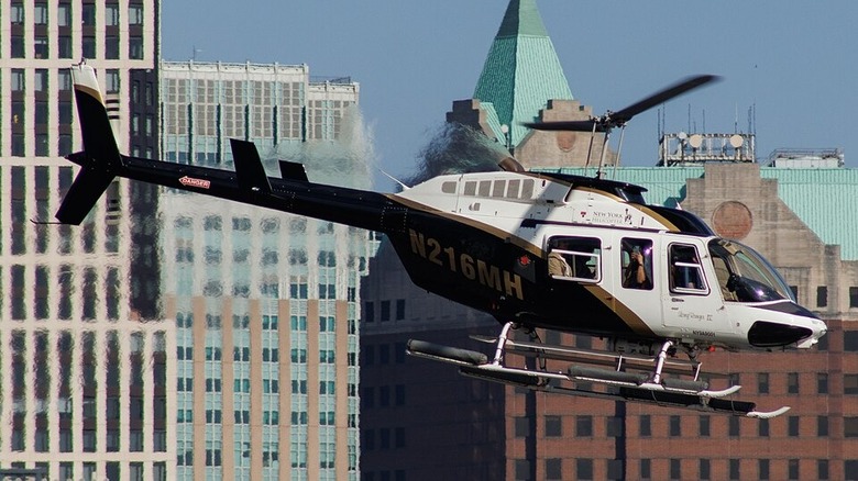 Bell helicopter flying in front of city skyline