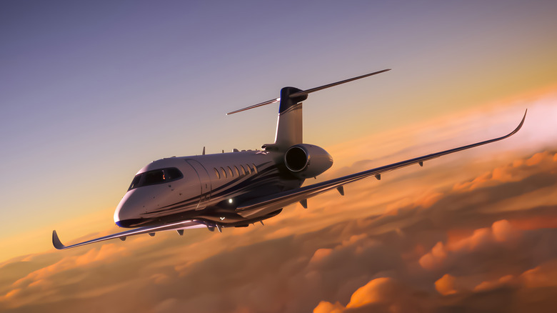 Private jet flying in sunset