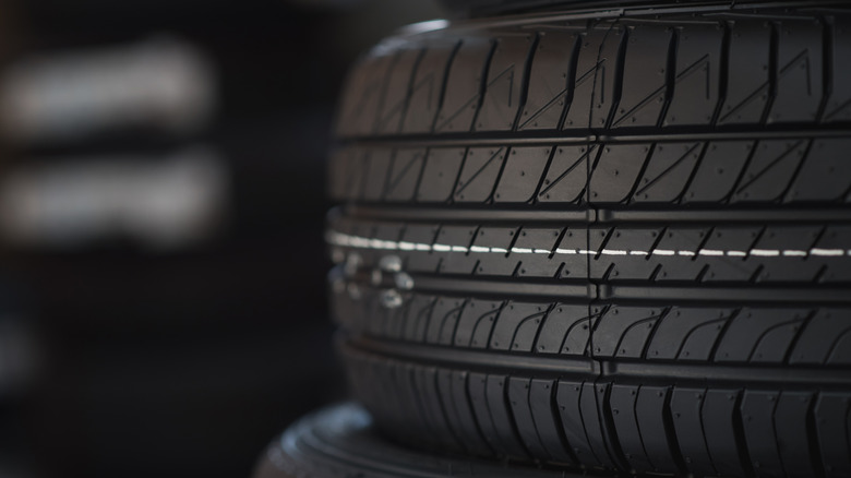 A close-up of a brand new tire with a white line